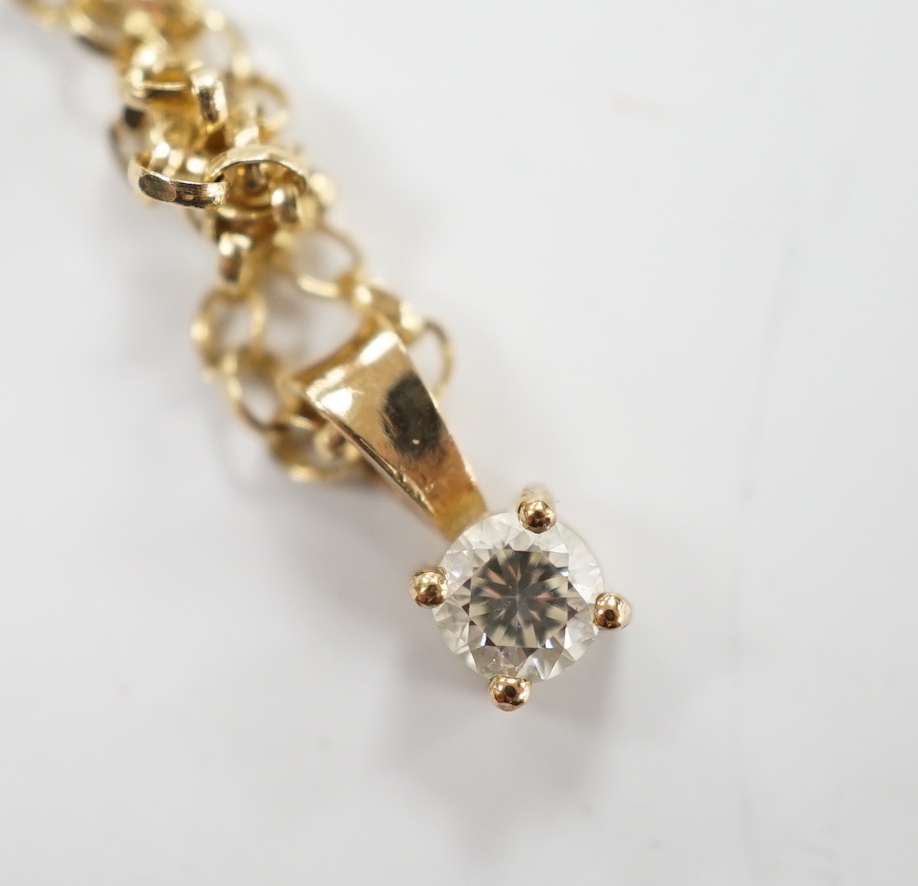 A modern 9ct gold and solitaire diamond set pendant, 9mm, on a 9ct chain, 38cm, gross weight 2.2 grams.